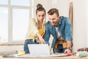 couple making renovations and looking at computer