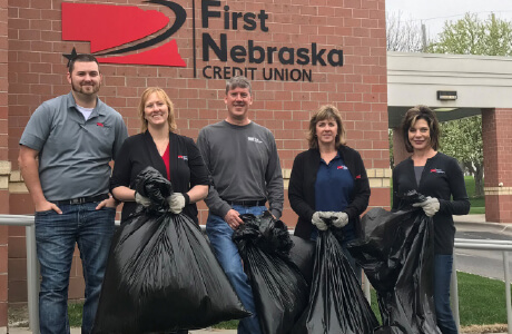 Group of employees holding trash bags after picking up trash in the area