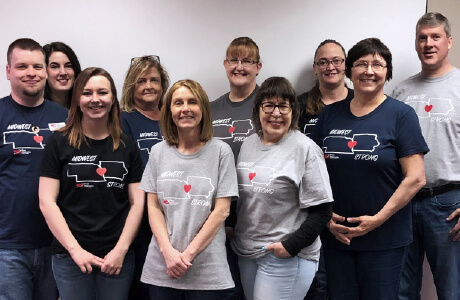 A group of employees wearing Midwest strong shirts to help support those affected by the floods in 2019