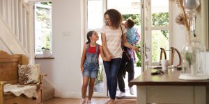 Family In Hallway Returning Home Together